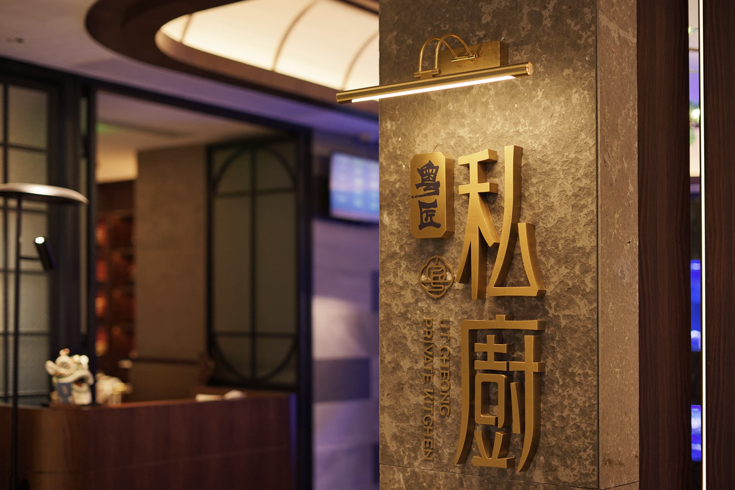 粵匠私廚入口，石材牆面上的金屬字招牌
